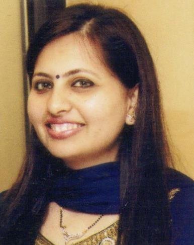 Portrait of Dr. Kapoor wearing traditional attire with academic books in background